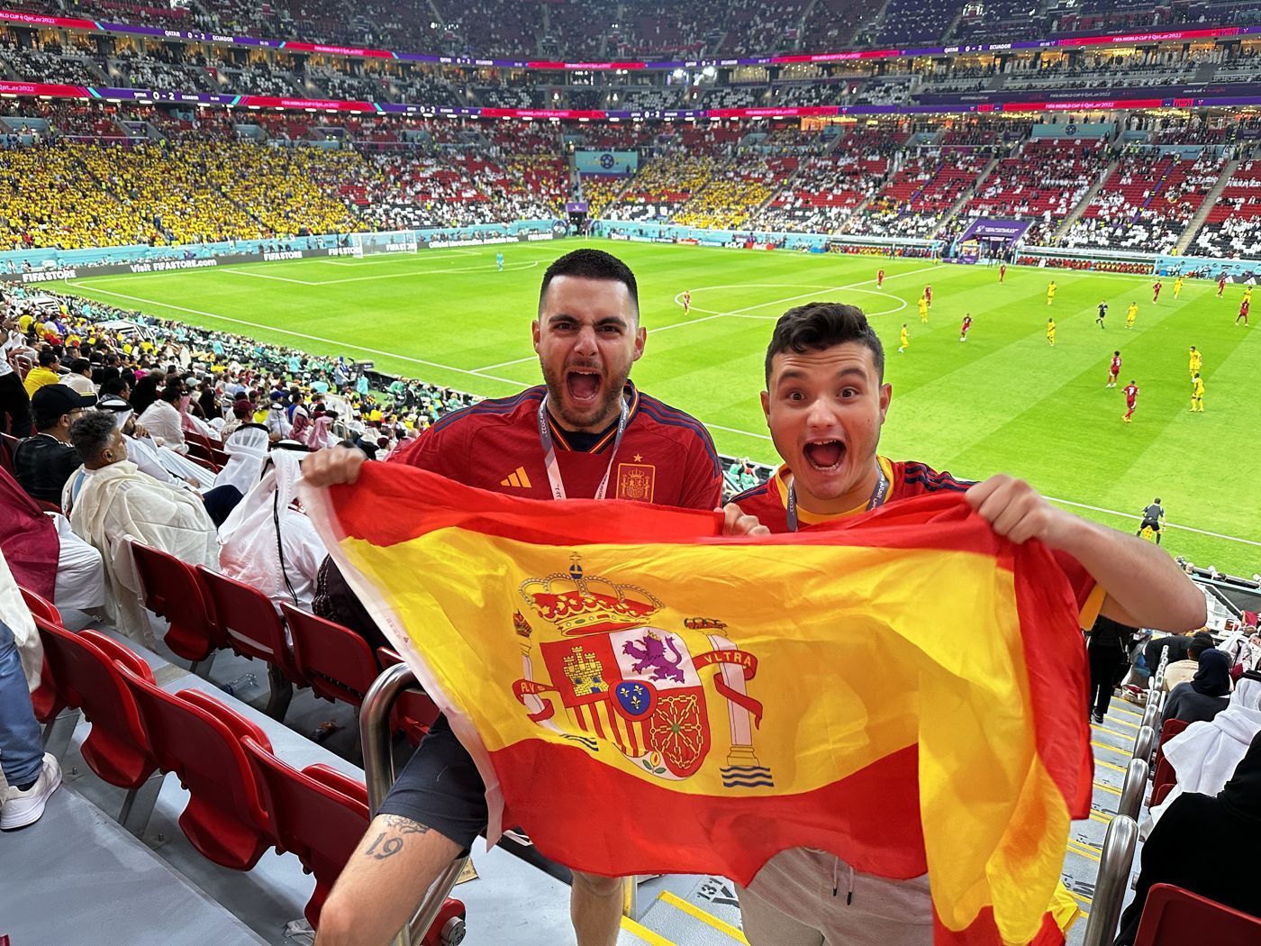 Kiko y un compañero con la bandera de España en la grada del Qatar–Ecuador